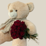 Large beige teddy bear holding a bouquet of red roses, Valentine’s Day flower and teddy delivery in Lebanon.