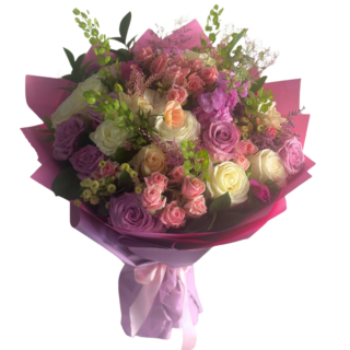 Soft pastel Mother’s Day flower bouquet with pink, cream and lavender roses wrapped in elegant pink paper.