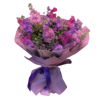 Elegant Mother’s Day bouquet with pink, purple and lilac seasonal flowers wrapped in soft pastel packaging.